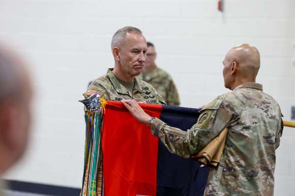 Major General Jack James unfurls the flag of the New York Army National Guard's 42nd Infantry Division during the division's drill held at the Troy Armory on Sept. 11, 2026. The unfurling of the division's colors by James, the division commander, at it's Troy , New York headquarters symbolized the division's official return home from a deployment to the Middle East which ended in June. The division headquarters played a key role during combat operations against Iran prior to returning home. (U.S. Army National Guard photo by Sgt. 1st Class Andrew Valenza)