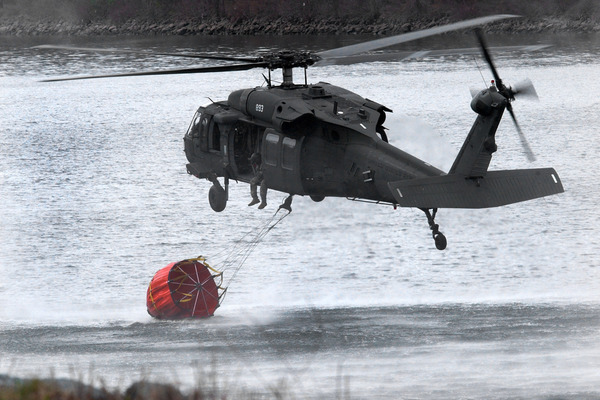 A New York Army National Guard UH-60 Black Hawk crew dips a Bambi Bucket into the Hudson River during firefighting training.
