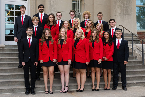 Twenty Husker students — 10 men and 10 women — pose for a group photo on the Nebraska's Union's south stairs. They are wearing black-and-red attire.