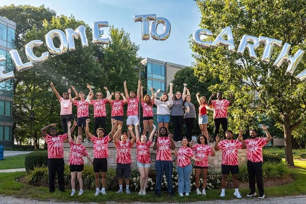 Orientation leaders cheering under "Welcome to Carthage" balloons.