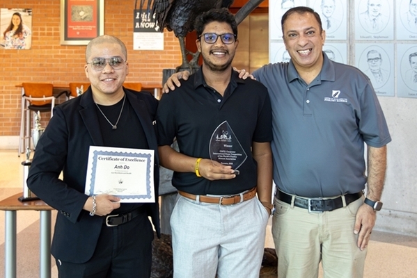 students stand together with award