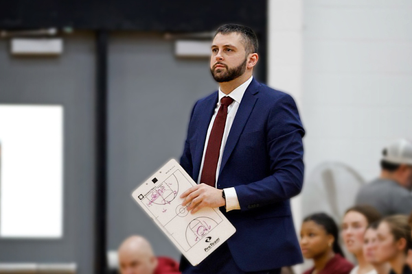 SUNY Potsdam women's basketball coach Michael Busby on the sideline in Jerry Welsh Gymnasium (Photo credit: Sophia Pleat ’26).