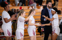 SUNY Potsdam women's basketball players high five on the sidelines.