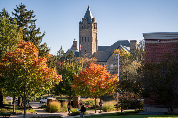This outdoor photo shows Ohio Wesleyan's University Hall framed by colorful fall foliage and other trees.