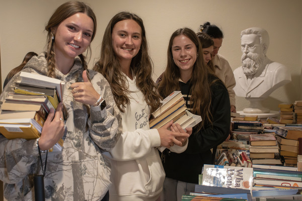 Trine University students pick up books at last year's Book Night in the T. Furth Center for Performing Arts. This year's event will include a fundraiser for Turning Point of Steuben County. (File photo by Emma J.V. Rode / Trine University)