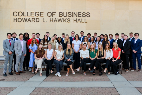 Thirty-nine University of Nebraska–Lincoln students in professional attire pose for a group photo west of Howard L. Hawks Hall.