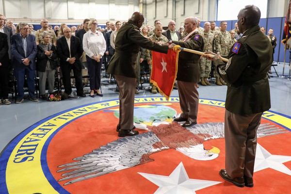 New York Army National Guard Major General Michel Natali, right, furls his two-star general's flag assisted by Command Sgt. Major Corey Cush, left, and Command Sgt. Major Leylan Jones, foreground, during Natali's retirement ceremony at New York National Guard headquarters in Latham, New York, on October 2, 2026. A general officer's flag accompanies him or her to official functions. Furling it symbolizes the end of a career. (U.S. Army National Guard photo by Stephanie Butler)