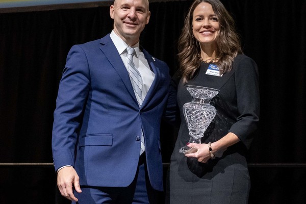 Trine University President Tony Kline, Ph.D., left, presents the Woman of Distinction award to Angie Logan, president and CEO of Cameron Health, with the university’s annual Woman of Distinction award during the annual Touchstone and Homecoming Celebration Dinner on Oct. 2. (Photo by Laura Pentecost / Trine University)