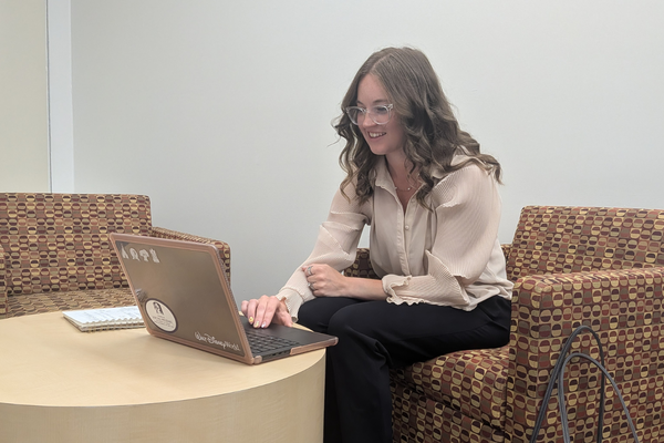 Arissa works on her laptop in the student lounge at the College of Integrated Health Sciences.