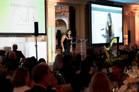 A student speaks in front of a crowd at a gala event.