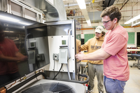 Two SUNY Canton students work on a heat pump simulator.  