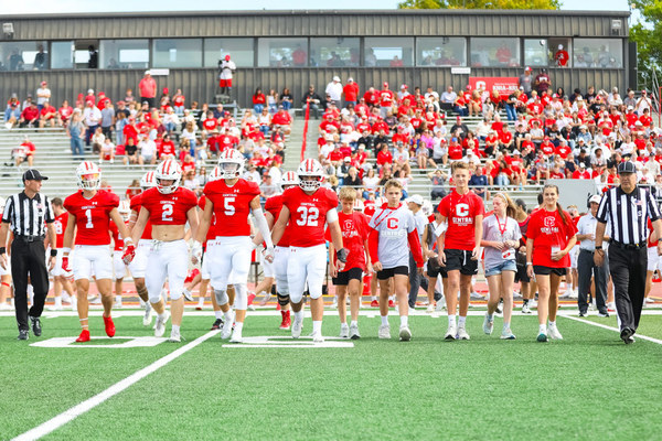 2025 Kid Captains and Central football team walk onto the field. 