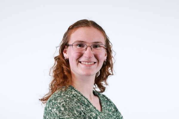 A person standing and looking at the camera with their arms folded.