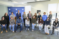 A group of students and administrators pose together for a photograph. 