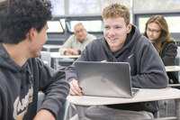 Two students work together in a classroom. 