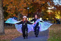 Students wear glowing wings and headbands and walk across campus.