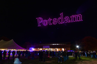 Drones spell out "Potsdam" in the sky.