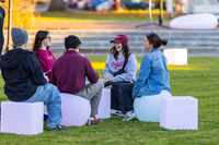 SUNY Potsdam students test out glowing seats set up in the Academic Quad as the Festival of Lights got underway.