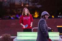 Students played glowing ping pong with the Festival of Lights decorations reflected in the glass of Brainerd Hall behind them.