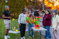 Students play glowing Jenga and gasp while their tower falls.