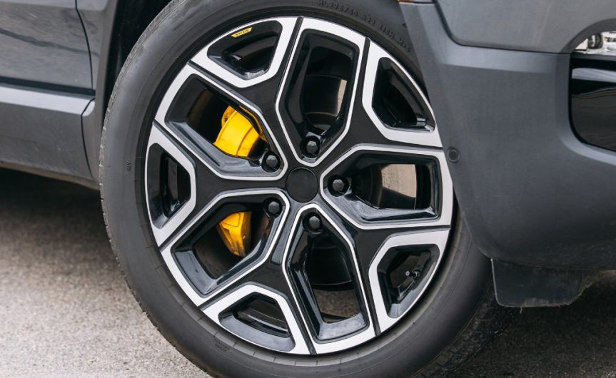 The tire of a car that is turned inward towards the vehicle. Details of the tread and rim are visible.