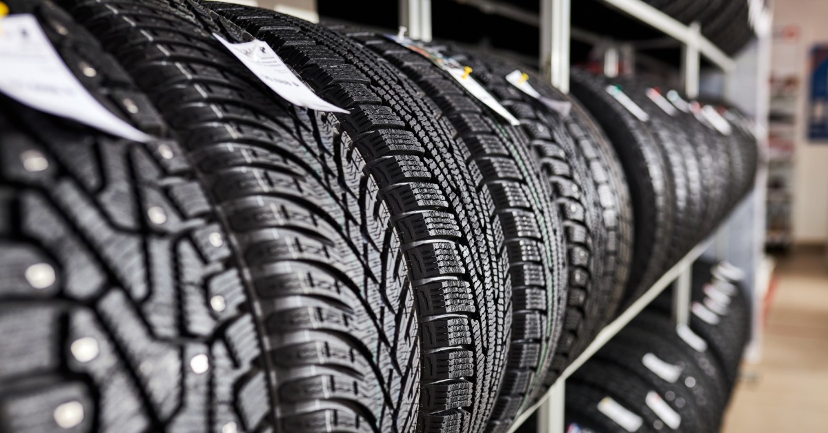 A shelving rack filled with similarly sized tires. The tires all have different tread patterns and tags.