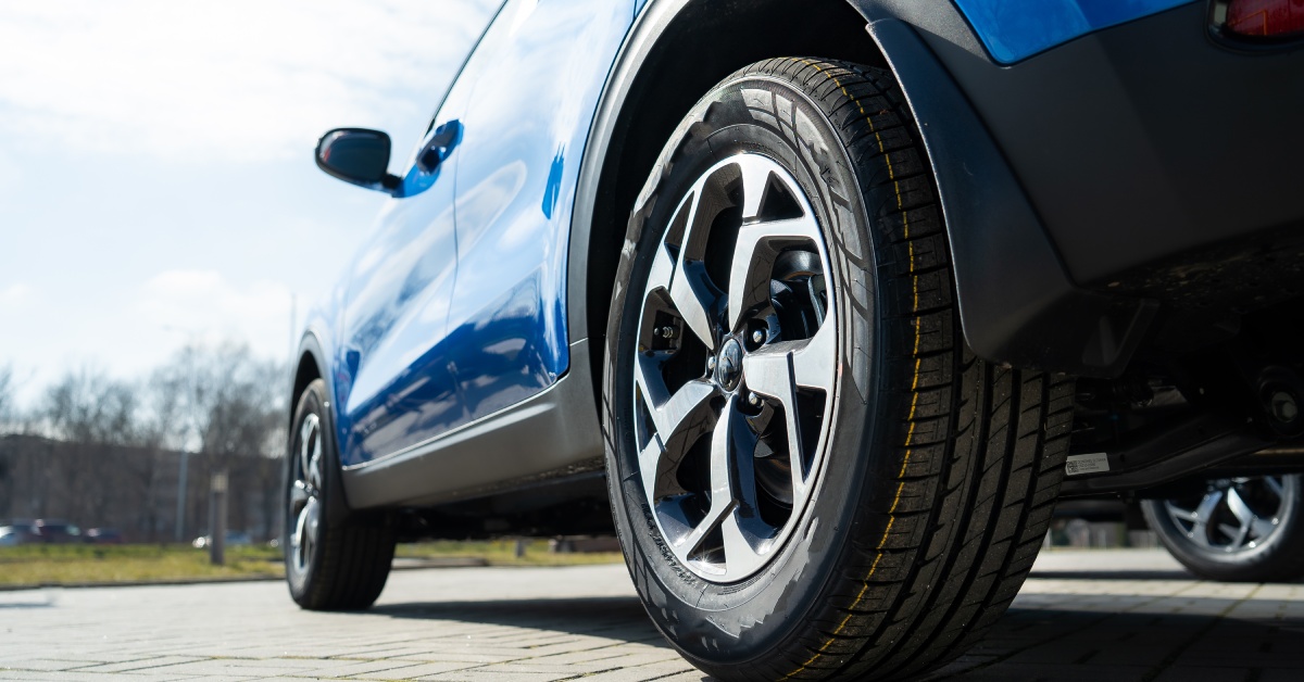 A blue car parked on a clear road. The sunlight is reflecting off the vehicle's exterior, highlighting how clean it is.