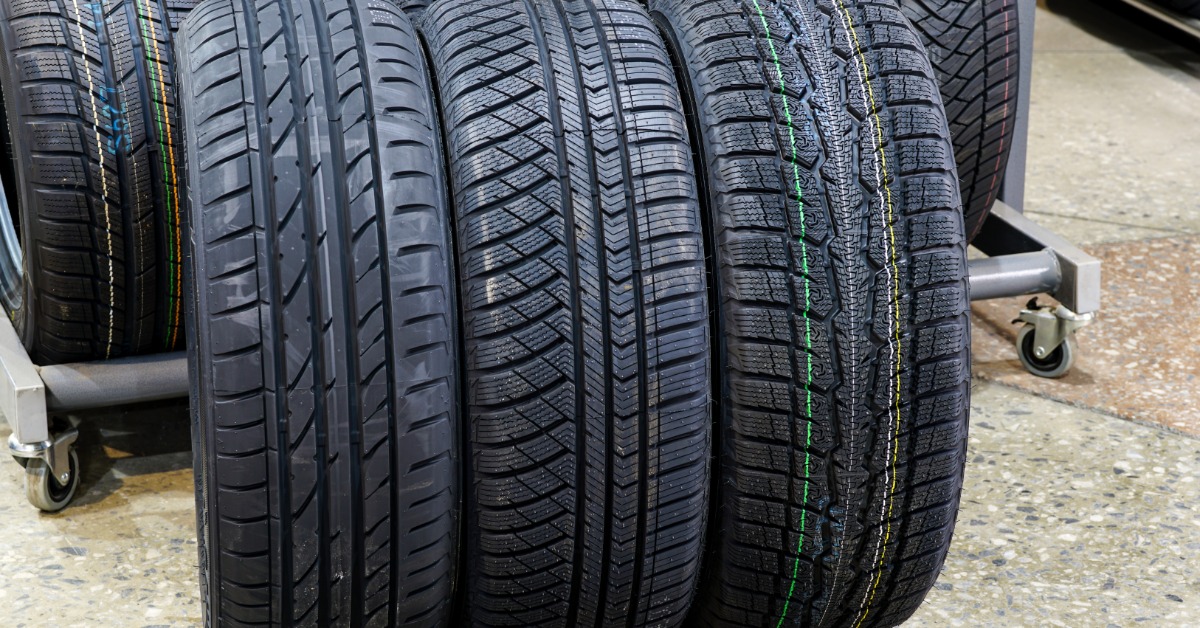 Three tires standing upright next to each other on a shop floor. Each tire has a different tread pattern.
