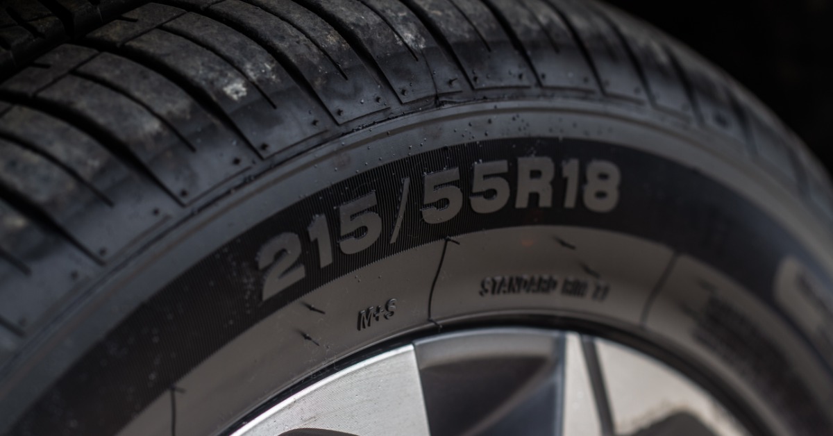 A close-up of the sidewall of a car tire with the number sequence displaying tire width, height, and wheel diameter.