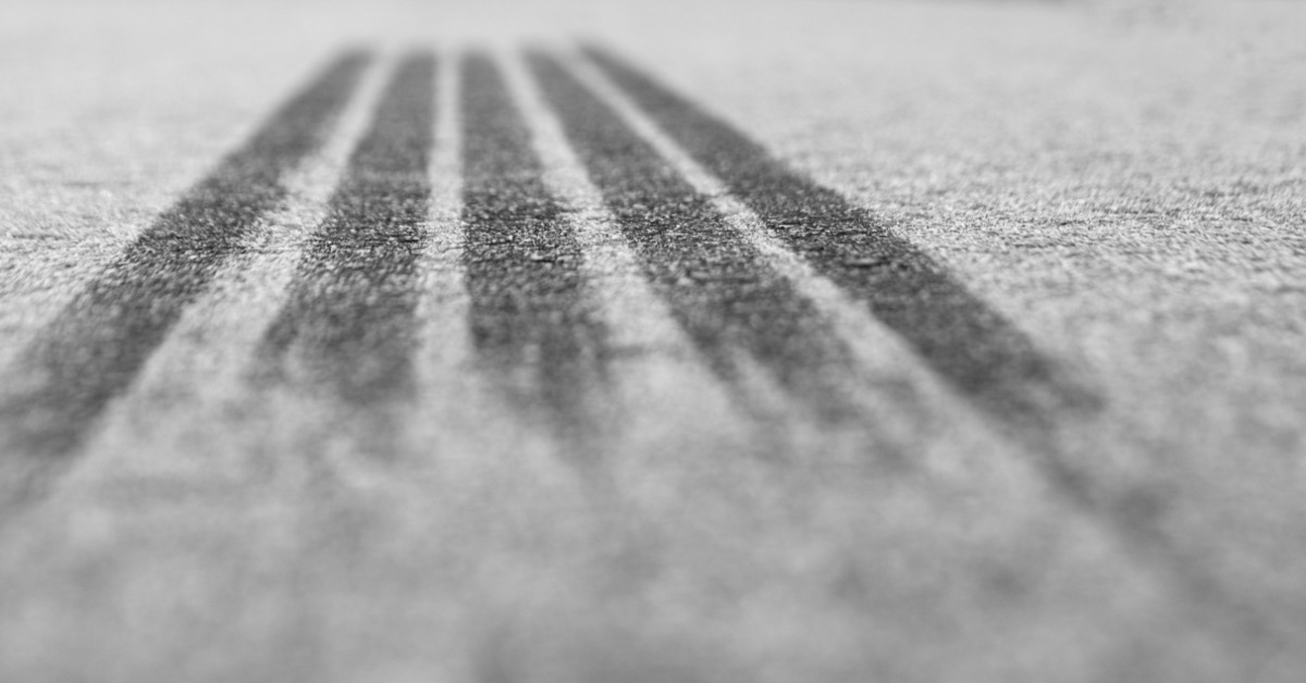 A close-up with a shallow depth of field of tire tracks left on pavement from intense braking during the day.