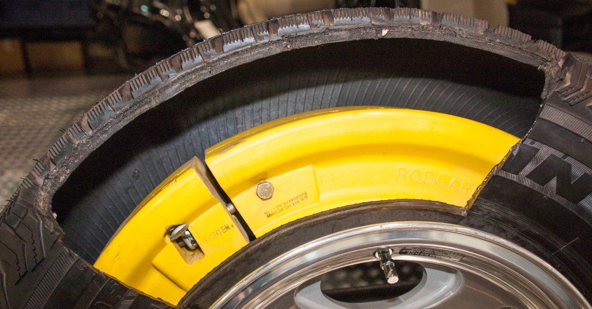 A run-flat tire with a portion of the sidewall cut out, exposing the technology that allows you to drive on a flat tire.