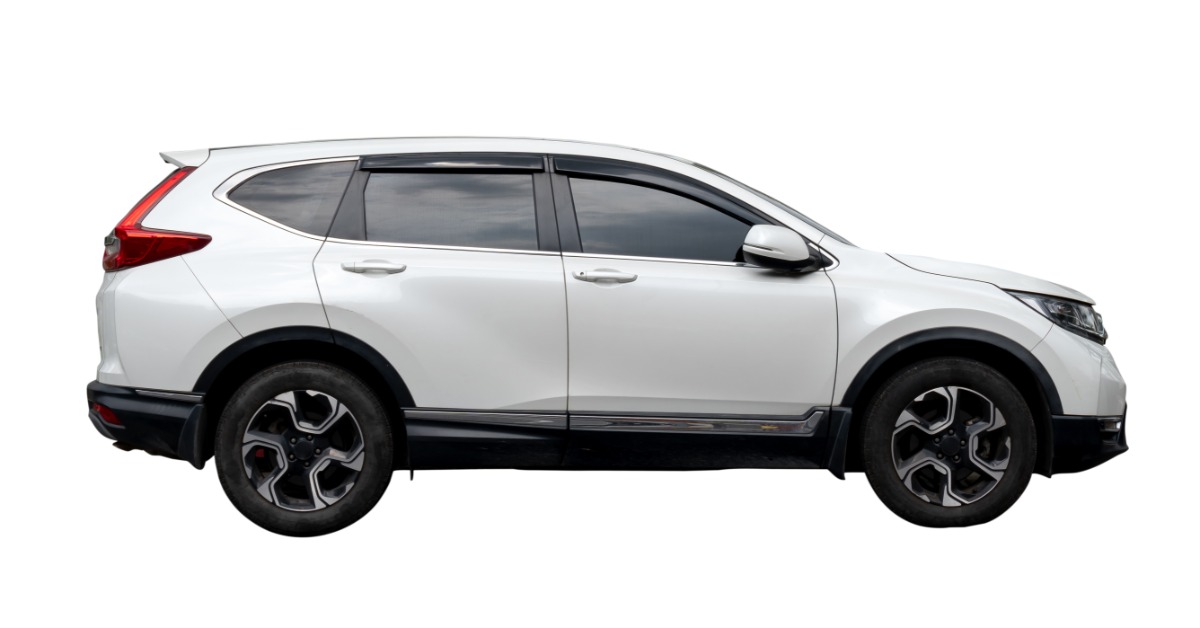 A side view of a white, four-door SUV with black trim and alloy wheels against a blank white background.