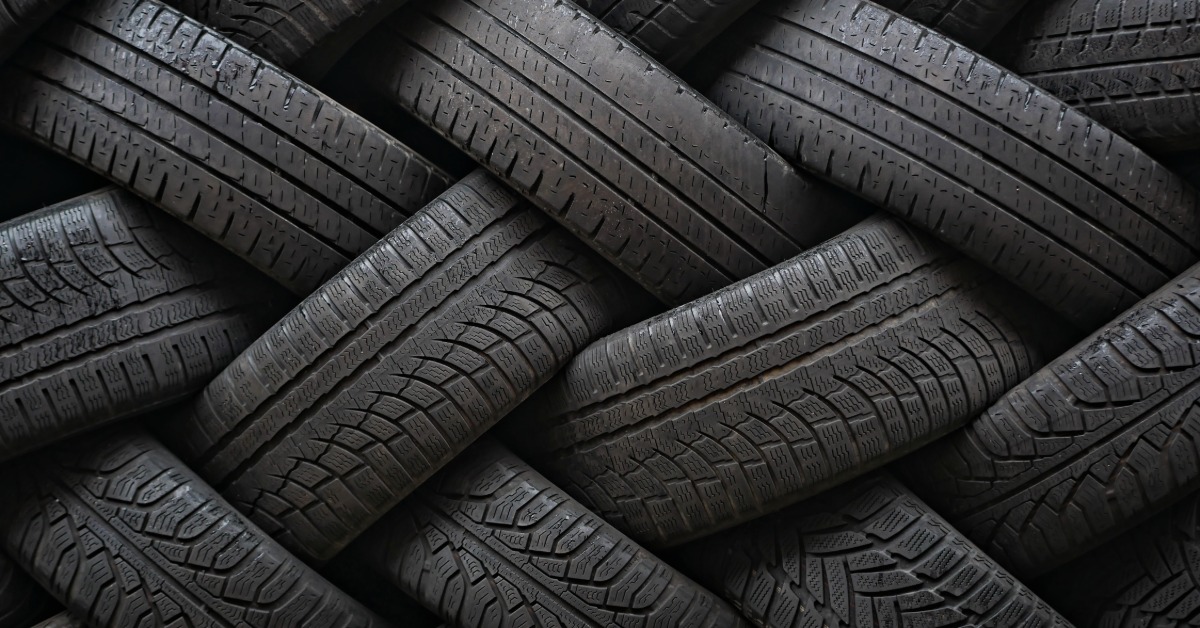 Several different types of tires with various forms of wear lie in opposite directions of each other to create a weave pattern.