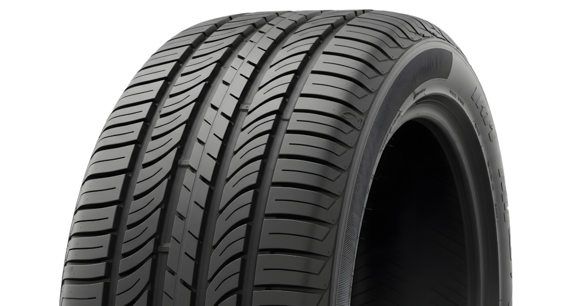 A close-up of the top half of an upright car tire without the wheel against a blank white background.