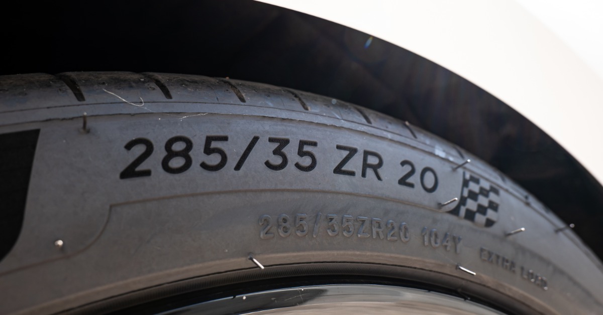 A close-up of an automotive tire to show its DOT code, which reads "285/35 ZR 20" on the side of the tire.