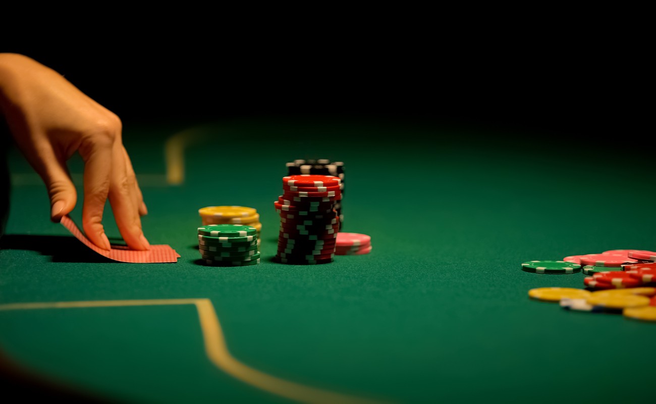 Female hands looking at cards on poker table