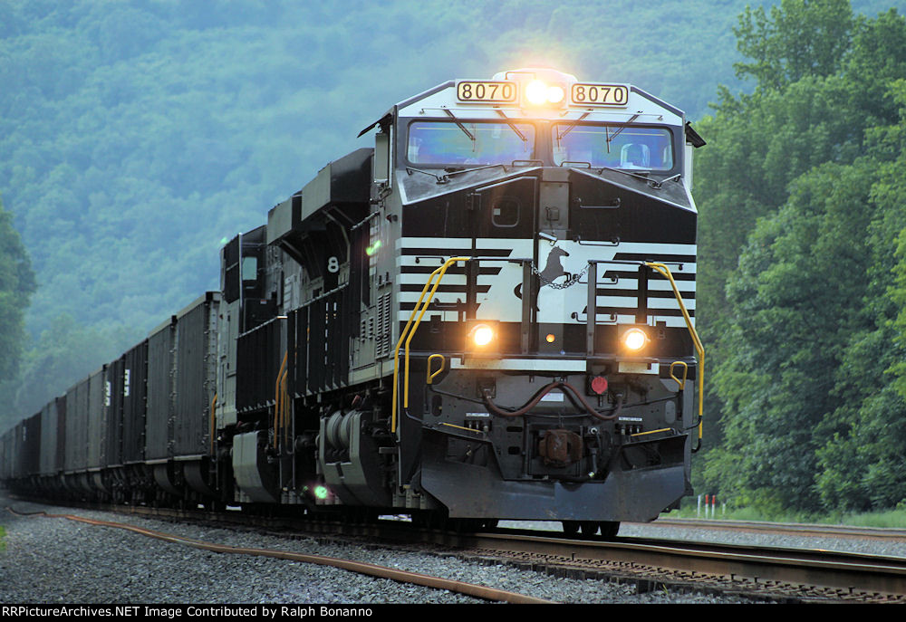 With the sun behind the hills, eastbound coal train 590 rumbles by with ...