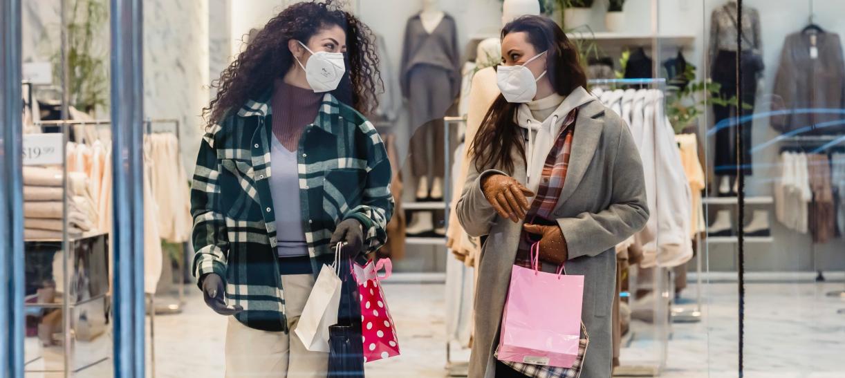Foto de dos mujeres con tapabocas comprando en una tienda.