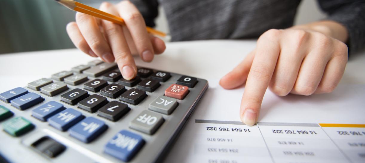 Foto de calculadora junto a documento con cifras. Ilustra nota sobre quiénes deben declarar renta en 2022.