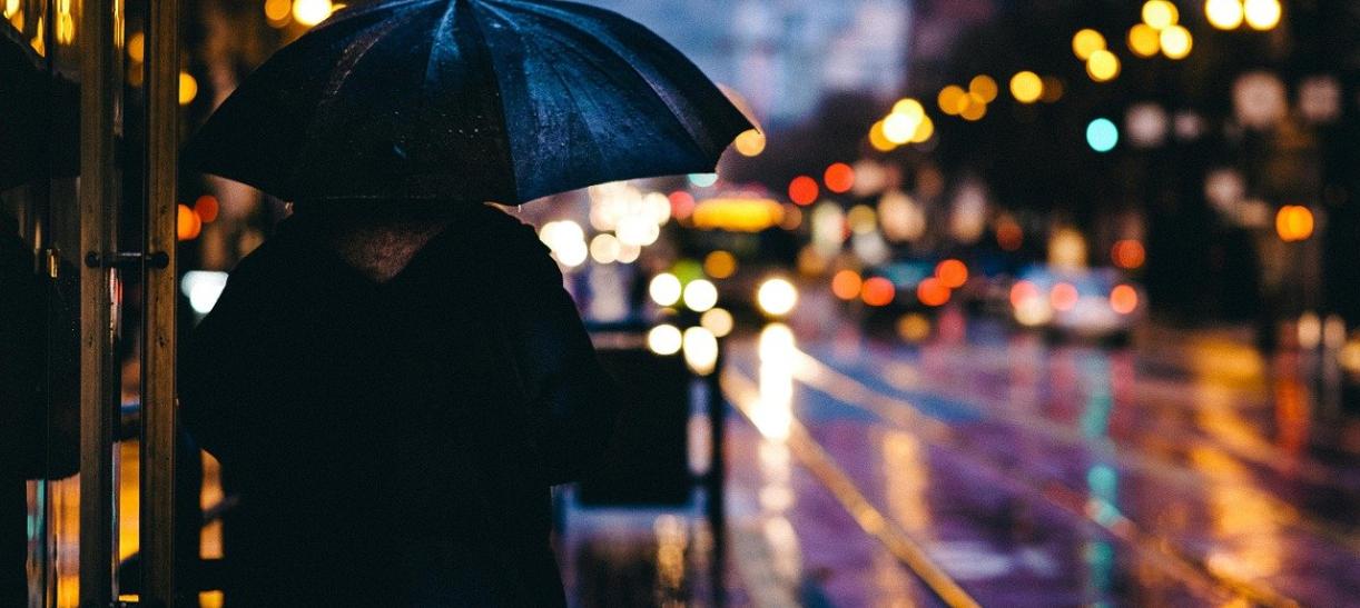 Persona con paraguas en una calle. Ilustra nota sobre segunda temporada de lluvias 2022