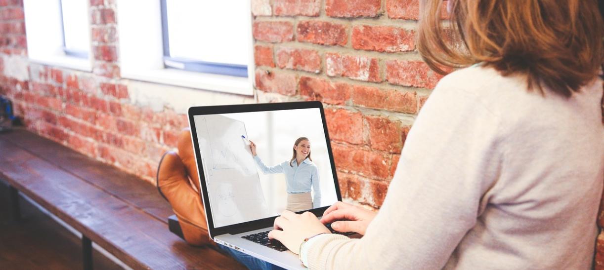 Mujer con computador en sus piernas. Ilustra nota sobre carreras técnicas y tecnológicas virtuales del SENA.