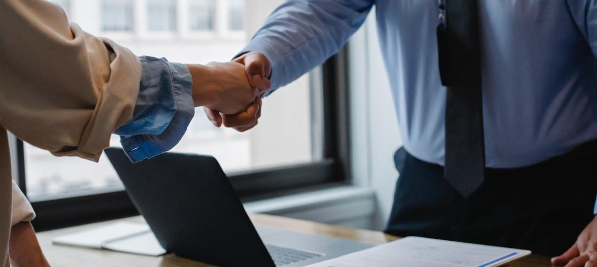 Dos personas estrechando la mano. Ilustra nota sobre ayuda económica por crear nuevos empleos.