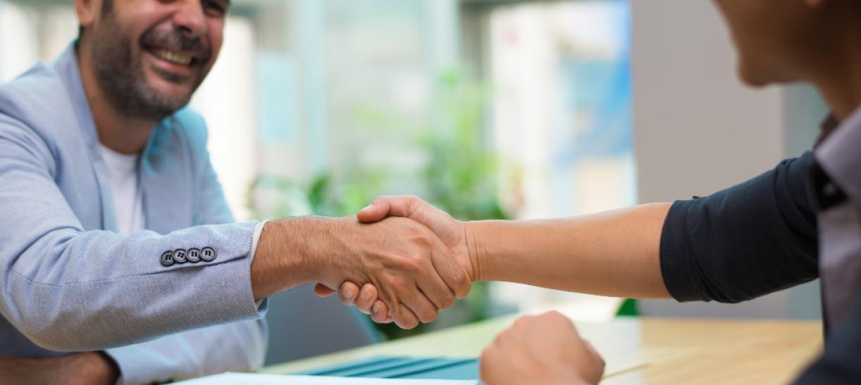 Hombre estrechando la mano con una mujer. Ilustra nota de talleres y ferias de trabajo del SENA.