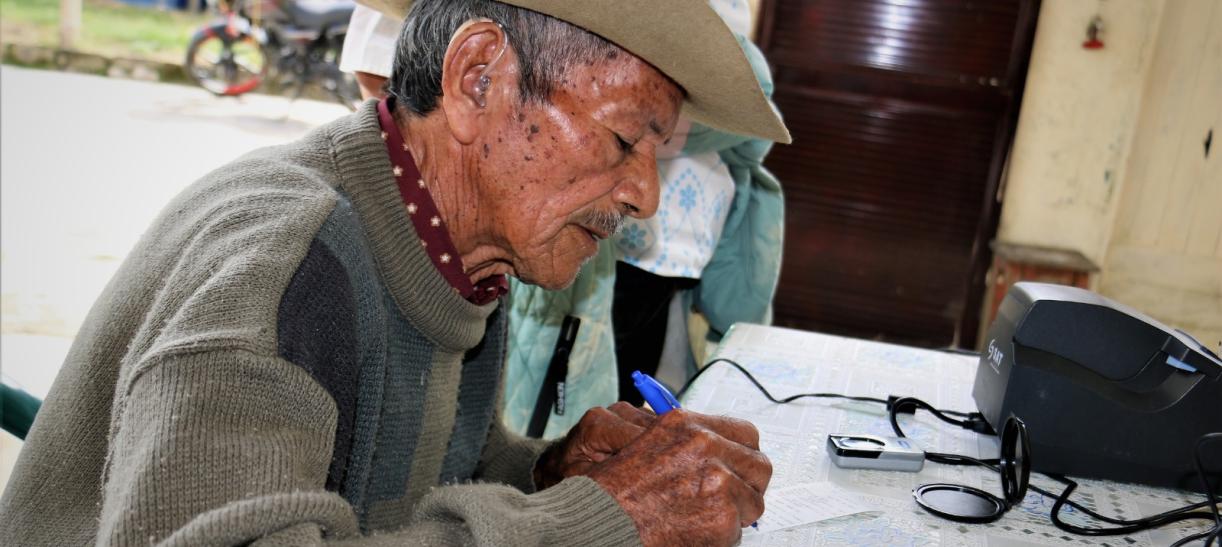 Persona de la tercera edad reclamando su giro de Colombia Mayor.