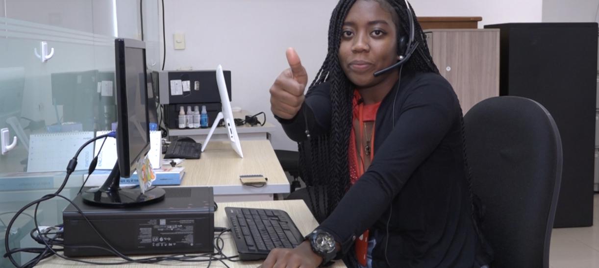 Mujer afrocolombiana en escritorio con computador. ilustra nota sobre 'Empléate sin fronteras'.