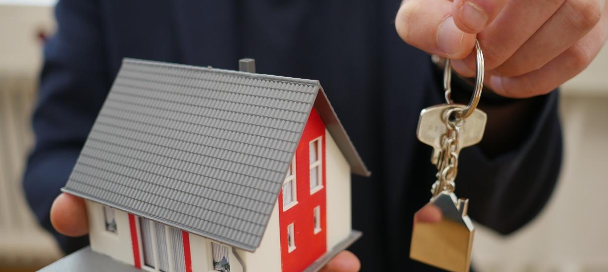 Persona con casa en miniatura y llaves en sus manos. Ilustra nota sobre Mi Casa Ya.