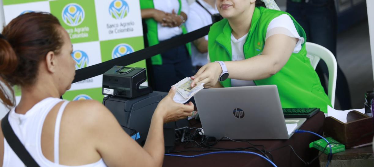Mujer recibe pago de Tránsito a Renta Ciudadana. Ilustra nota sobre municipios dónde cambió fecha de pago.