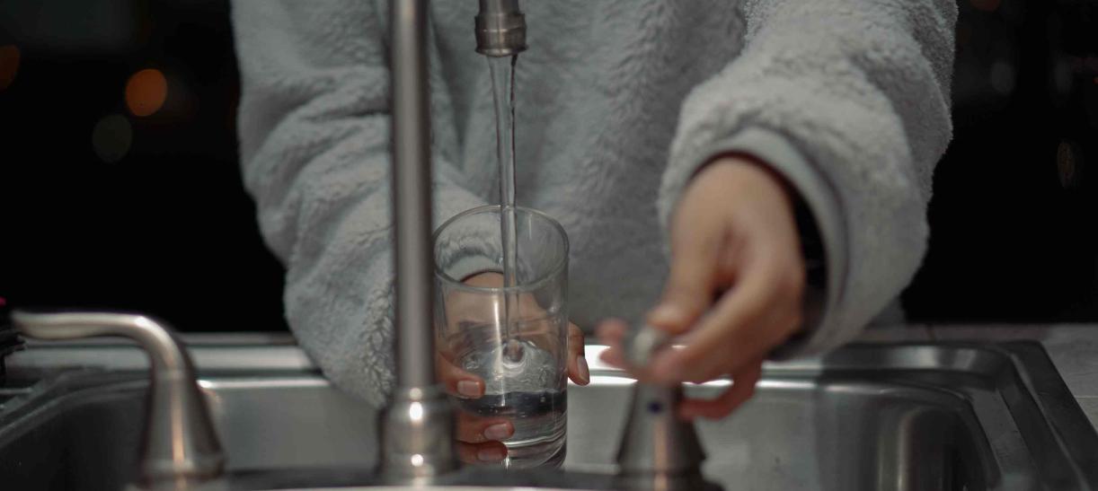 Mujer empleando acciones para ahorrar y cuidar el agua en casa
