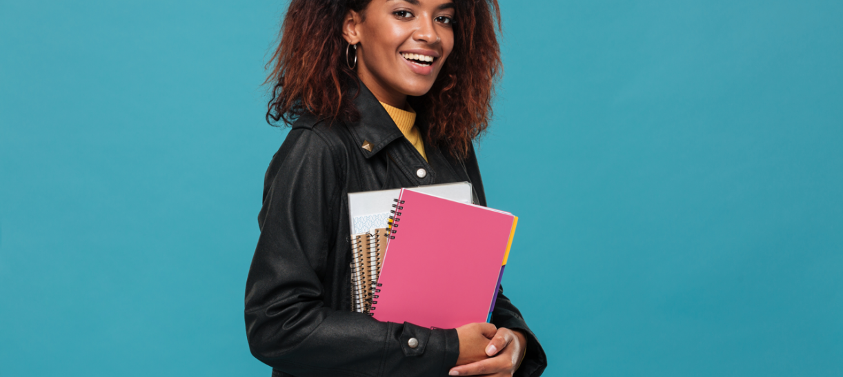Mujer de piel negra con libros en sus brazos. Ilustra nota sobre becas de inglés para comunidades afro e indígenas.