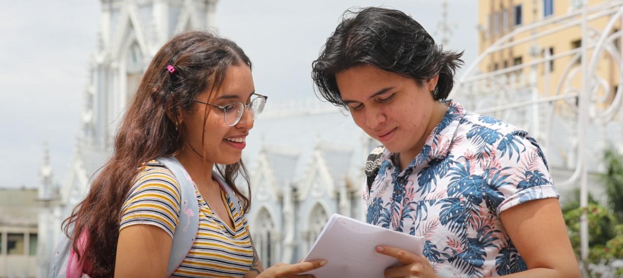 Jóvenes hombre y mujer con hojas en la mano. Ilustra nota de pago de Jovenes en Acción.